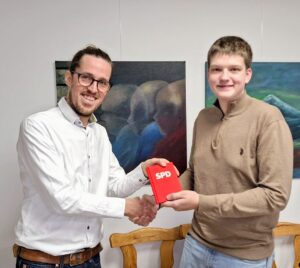 Vorsitzender Andreas Osterkamp überreicht Milo Bröckerhoff sein Parteibuch