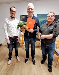 Die Vorsitzenden Andreas Osterkamp und André Schneidenbach überreichen Christian Wellering offizielle und persönliche Glückwünsche für 50 Jahre Mitgliedschaft in der SPD.